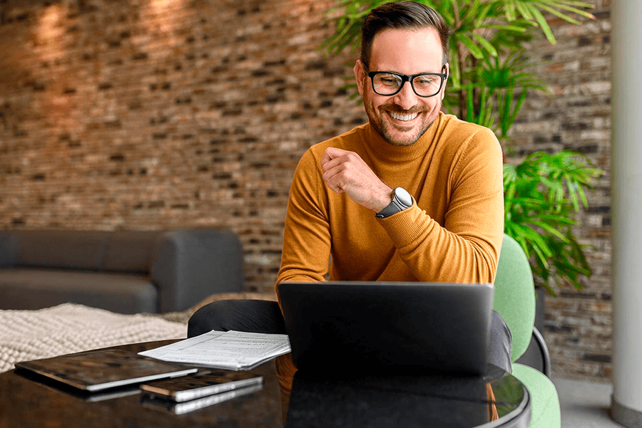 Homem de blusa amarela olhando notebook